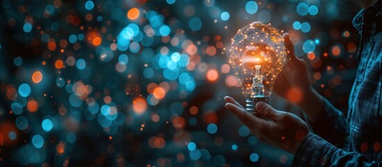 Poster - Person holding a glowing light bulb with bokeh background.