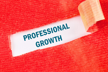 Business concept. The phrase, text, and words of PROFESSIONAL GROWTH are written on white paper under red torn paper