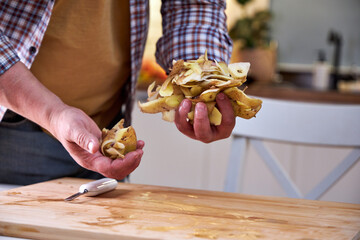 man in the kitchen peeling potatoes