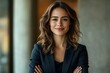 © Imagentive - Confident Female Executive with Arms Crossed in Office Setting.