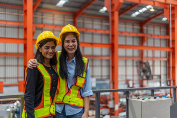 two female mechanical engineers from different ethnicities and cultures having a discussion over a p