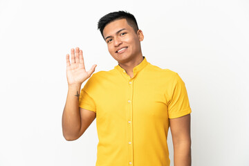 Young Ecuadorian man isolated on white background saluting with hand with happy expression