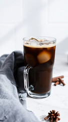 Wall Mural - glass iced coffee with ice cubes on a marble surface