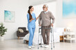 © New Africa - Nurse helping senior man with walking frame in clinic