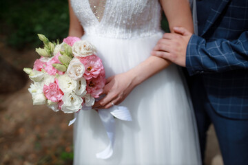 Wedding bouquet in the hands of the bride at the ceremony. Touching the hands of the bride and groom. Wedding jewelry. Wedding rings. The tenderness and beauty of the wedding ceremony.