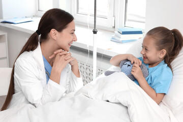 Sticker - Doctor examining little girl on bed at hospital