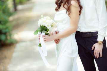 Wedding bouquet in the hands of the bride at the ceremony. Touching the hands of the bride and groom. Wedding jewelry. Wedding rings. The tenderness and beauty of the wedding ceremony.