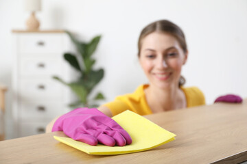 Canvas Print - Woman cleaning table with rag at home, selective focus