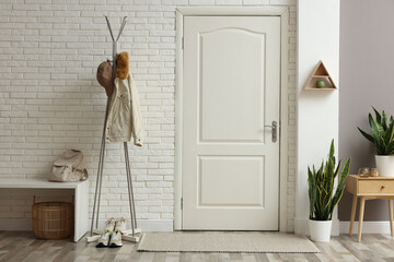 Canvas Print - Metal rack with jacket, cap and sneakers in hallway