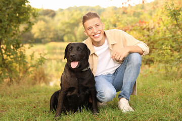 Wall Mural - Smiling man with cute dog outdoors on autumn day