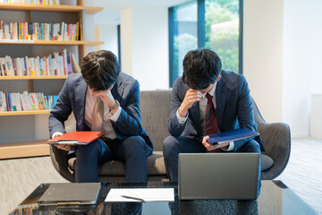 悩む2人の男性ビジネスマン