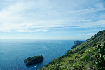 Mediterranean coastal view on the sea and sky in the sunny summer day, green mountain against the blue water and sky