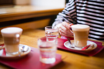 Two Lattes on Table with Woman Hand