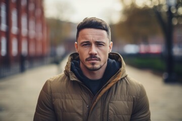 Portrait of a handsome young man looking at camera in urban background