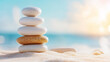 © zamuruev - A collection of carefully stacked stones rests on soft sand, evoking a sense of calm and balance by the beach
