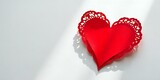 Red paper heart with lace detail on a white background