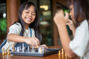 Two young girls playing a game of chess