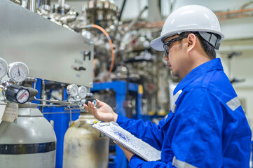 Asian engineer working at Operating hall,Thailand people wear helmet  work,He worked with diligence and patience,she checked the valve regulator at the hydrogen tank.