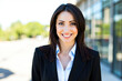 © Minerva Studio - Businesswoman smiling in front of office building