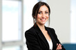 © Minerva Studio - Businesswoman smiling with folded arms in office