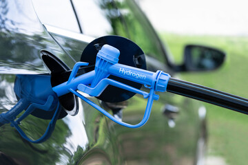 Wall Mural - Close up of fuel cell car with connected hydrogen fueling nozzle.