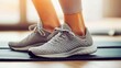 © 성환 이 - A close-up of a woman’s feet in stylish training shoes, positioned on a yoga mat, emphasizing her readiness for a workout
