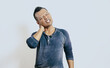 © PRIYO DWI SAPUTRO - Tired asian man touching neck with pain expression isolated on white background.