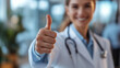 © oceanrider - Doctor giving thumbs up gesture symbolizing success and positivity in a blurred background
