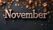 © shri radha - A closeup image of the word November in silver 3D lettering with golden outlines, set against a dark background with scattered brown autumn leaves.