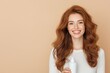 © Natalia - Smiling woman with long chestnut hair holding shampoo against a softly lit beige background