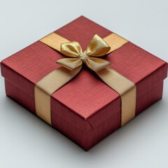 A beautifully wrapped red gift box with a gold ribbon and bow on a neutral background