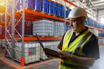 Poster - Man warehouse manager. Logistics storehouse supervisor. Warehouse manager holding laptop. Man in industrial zone of chemical factory. Warehouse supervisor uses laptop to record goods