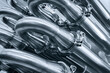 © Aleksandr Matveev - A series of pipes are shown in a close up. The pipes are silver and appear to be connected to one another. Concept of industrial machinery and the importance of the pipes in the process