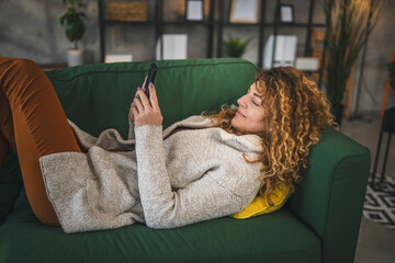 One woman with curly hair at home use mobile phone smartphone sms texting or browse internet