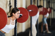© JackF - Young woman in sportswear training with barbell in gym