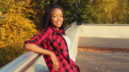 Wall Mural - Portrait of stylish young african woman with dreadlocks posing wearing casual in the city