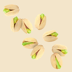 Poster - Tasty pistachios in air on color background