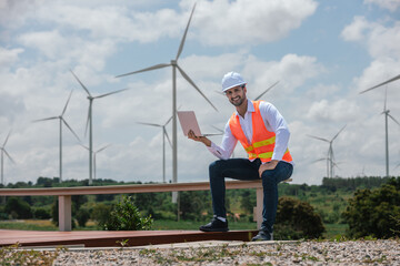 Fototapete - Engineer wearing safety uniform holding laptop discussed plan about renewable energy at station energy power wind. technology protect environment reduce global warming problems.