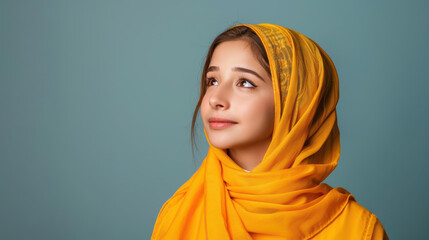 A young woman in traditional Arabic attire gazes upward, exuding beauty and elegance in her cultural expression.