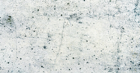 Close-up of a weathered white concrete wall with black spots and cracks. Classic retro texture for poster banner background and other digital needs.