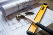 © Emanuel - Blueprints with construction tools like a hammer and level nearby