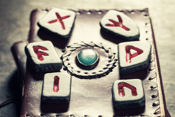 Poster - Black stones with futhark sign on leather book