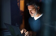 © Halfpoint - Handsome man working from home office at evening, using laptop. Screen glow illuminates man's face. Telecommuting and home office.