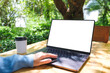 © Farknot Architect - Mockup image of a woman using and touching on laptop computer touchpad with blank white desktop screen in the outdoors