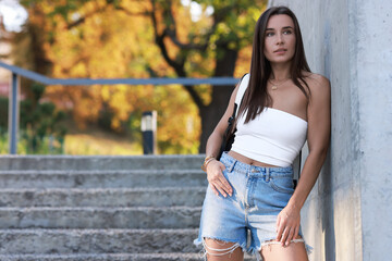 Wall Mural - Beautiful woman wearing stylish denim shorts outdoors, space for text