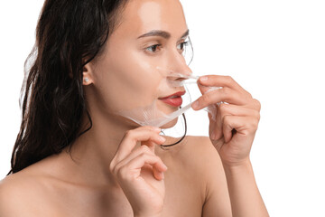 Canvas Print - Beautiful woman peeling off face mask on white background