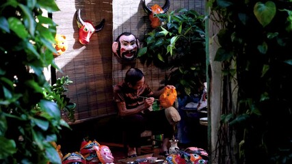 Wall Mural - Old man making traditional Vietnamese paper mache masks in his house in Nam Dinh city, Vietnam