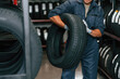 © standret - In gloves, professional worker with tire. Man is in the tire fitting car service