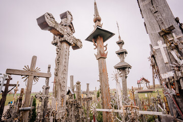 A large collection of wooden crosses, crucifixes, and rosaries displayed at Kryžių Kalnas (Hill of Crosses), symbolizing faith, devotion, and pilgrimage.