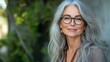 © liliyabatyrova - A woman with long gray hair and glasses is smiling